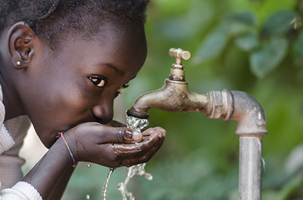 African child drinking from a tap: this may or may not be safe